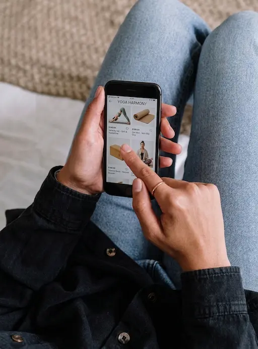 Una persona mira desde su celular un catálogo digital de productos de yoga.